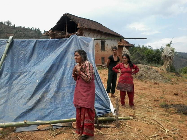 A woman stands outside of a tent in Koshi Dekha village in the Kavre District of Nepal. (Rinzee Lepcha)