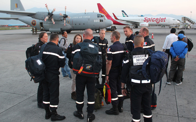 United Nations and other international relief workers stand at Kathmandu airport in Nepal on Monday. Inclement weather and logistical pressures have slowed down relief for Nepal earthquake victims. (CNS/Anto Akkara) 