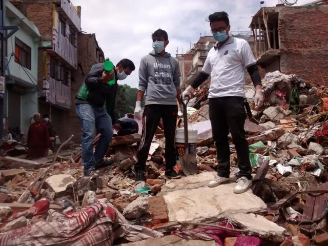 Students from St. Xavier's College volunteer in the Kathmandu Valley to help with rubble removal and talking about sanitation and hygiene with people living in tents after the earthquake. (Courtesy of Nepal Jesuit Society)