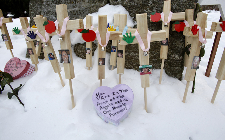 Crosses are seen in the snow Wednesday as part of a makeshift memorial in Newtown, Conn. (CNS/Reuters/Carlo Allegri)
