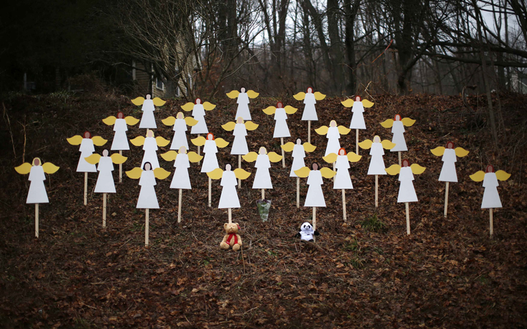 Twenty-seven wooden painted angels created by Eric Mueller are displayed outside his home Sunday in Newtown, Conn. (CNS/Reuters/Mike Segar)