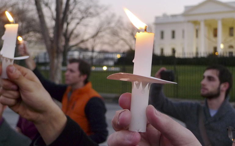 Supporters of gun control legislation hold candles during a rally in front of the White House in Washington Dec. 14 after the shooting at an elementary school in Newtown, Conn. (CNS/Reuters)