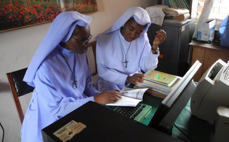 Immaculate Heart of Mary Sr. Mary Nicolette Ihenacho, left, executive secretary of the Nigeria Conference of Women Religious, and Immaculate Heart of Mary Sr. Mary Amanda Nwagbo, assistant secretary of the conference, look over the 2014 edition of their directory in her office. (Melanie Lidman)