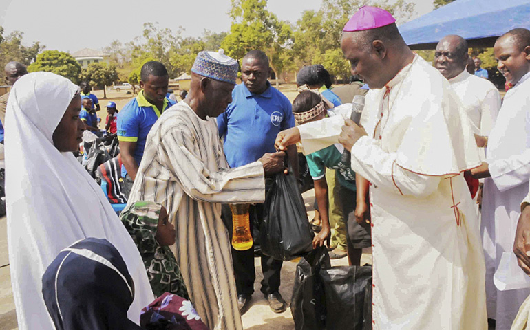 Archbishop Ignatius Kaigama presents relief material to internally displaced people in Jos, Nigeria, on Jan. 20. Many now flee to neighboring Cameroon to escape Boko Haram attacks. (CNS/EPA)