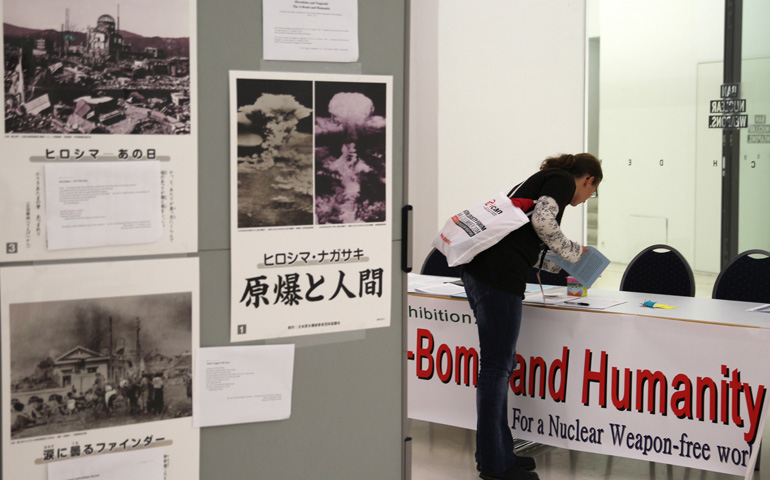 A woman picks up literature at the International Campaign to Abolish Nuclear Weapons' Civil Society Forum in Vienna on Dec. 6. (CNS/Chaz Muth) 