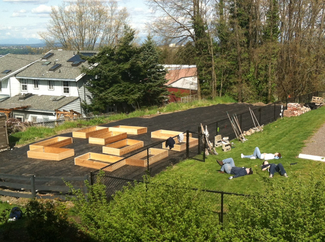 Our Lady of Guadalupe Parish volunteerrs take a break during the construction of 10 garden beds that supply produce for the parish's Lettuce Pray program, which supports area food banks. The gardens will be watered by a roof rain catchment system. (Our Lady of Guadalupe Parish)