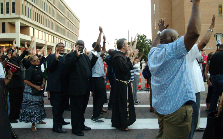 Clergy of various faiths chant “Hands up! Don’t shoot!” in front of the Buzz Westfall Justice Center in Clayton, Mo. (NCR photo/Robyn Haas)