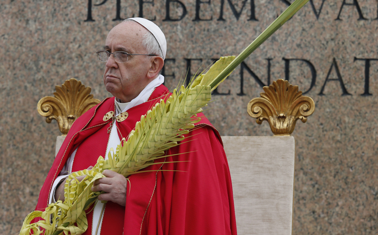 Pope Francis holds palms at the start of Palm Sunday Mass in St. Peter's Square on Sunday at the Vatican. (CNS/Paul Haring)