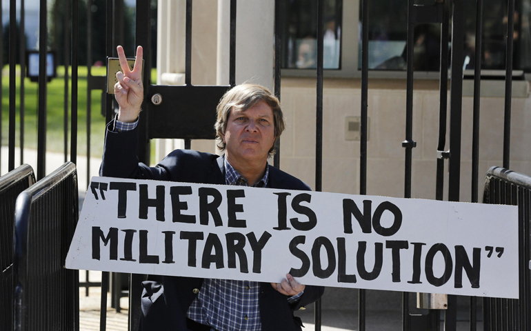 Fr. John Dear protests Sept. 23 at the entrance to the White House in Washington. (CNS/Reuters/Larry Downing)