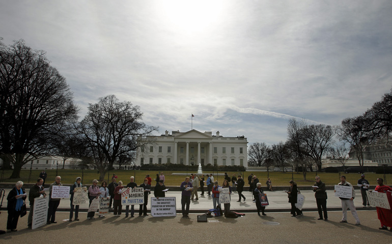 Peace and justice activists hold signs calling for societal repentance during a prayer service in front of the White House in Washington Feb. 22, 2012. (CNS/Peter Lockley)
