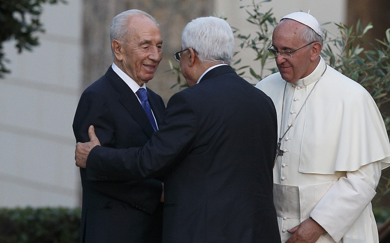 Pope Francis looks on as Israeli President Shimon Peres, left, and Palestinian President Mahmoud Abbas embrace during an invocation for peace Sunday in the Vatican Gardens. (CNS/Paul Haring)