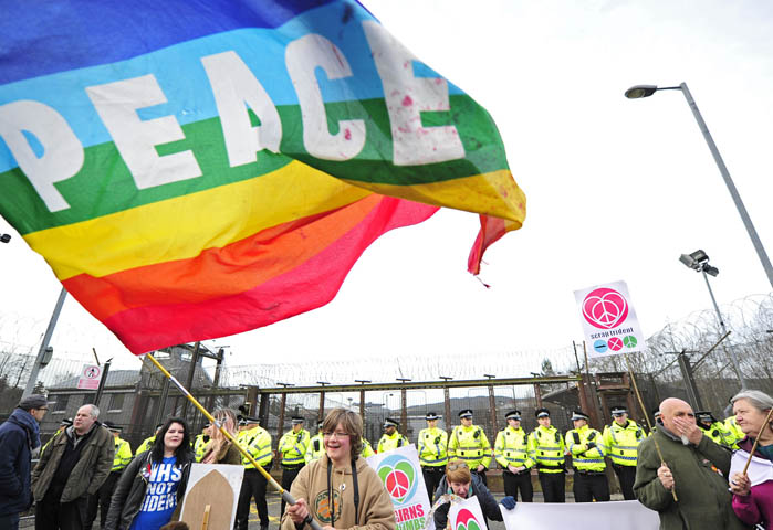 A woman waves a flag during a nuclear weapons protest April 13 outside Faslane Naval Base in Helensburgh, Scotland. (CNS/EPA/Joey Kelly)