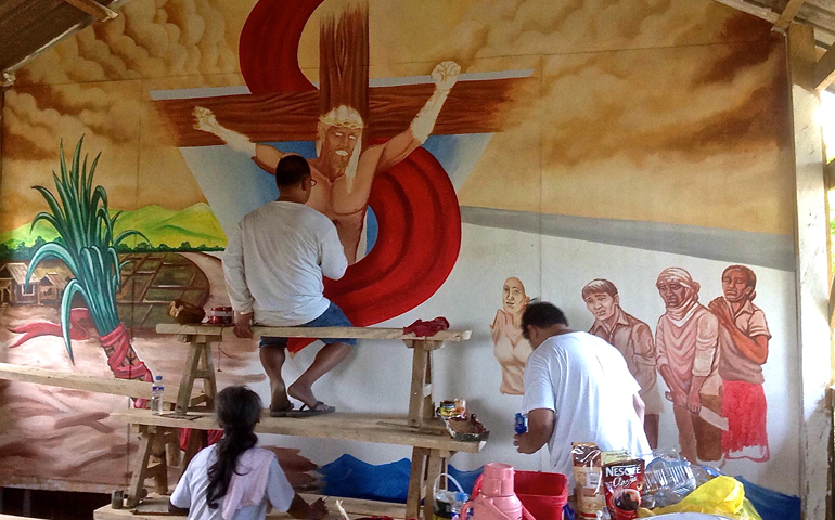 Members of a provincial group of artists paint a mural for the chapel rebuilt by residents in Escalante Town, Negros Occidental Province, after Typhoon Haiyan destroyed it in November. (Courtesy Br. Jaazeal Jakosalem of the Augustinian Recollects)