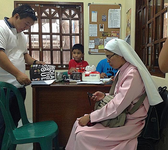Mary Queen of Heaven Missionaries Junior Sr. Joy Culaiban checks her cellphone. The phone is an invaluable tool to connect the sisters with sex workers who want help leaving prostitution. (N.J. Viehland)