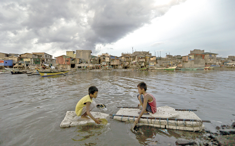 Children paddle in water in Navotas City, Philippines, May 10. (CNS/EPA/Ritchie B. Tongo)