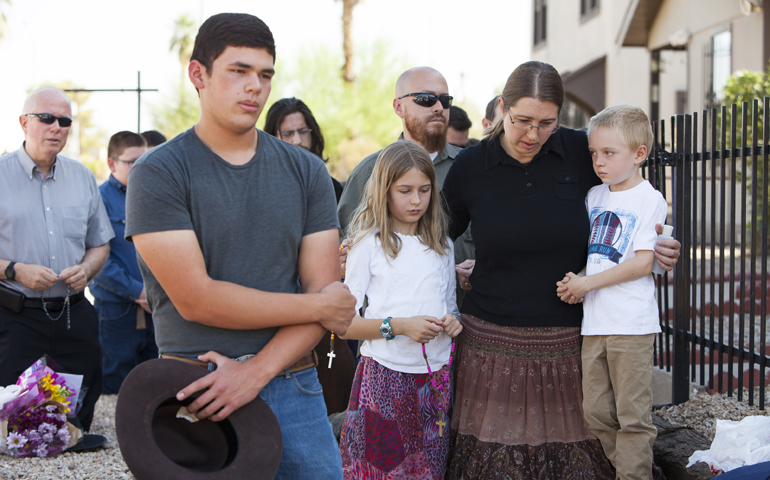 Parishioners, including Jennifer Gustke, right, and her children, pray the rosary June 12 near Mater Misericordiae (Mother of Mercy) Mission in Phoenix the morning after a priest was killed and another critically injured during an attack at the mission's rectory the night before. (CNS/Nancy Wiechec) 