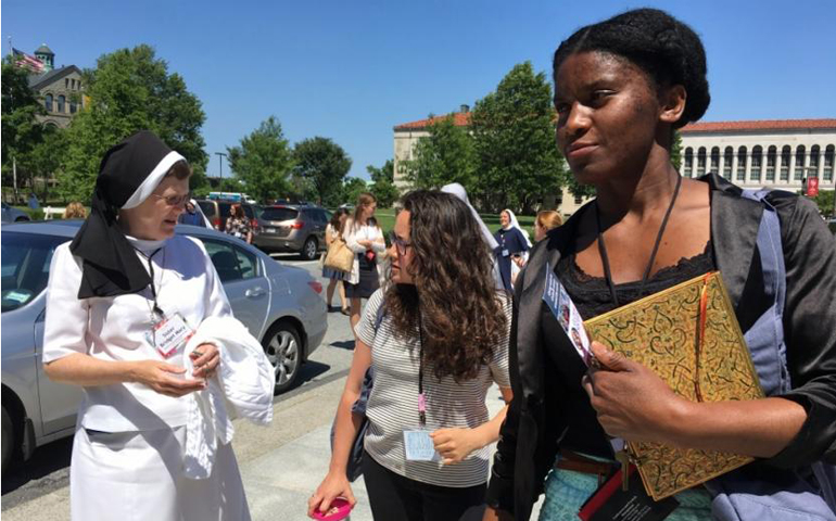 Regina Karluah, left, a college student from Philadelphia, walks to Mass on June 9. (GSR/Dawn Araujo-Hawkins)