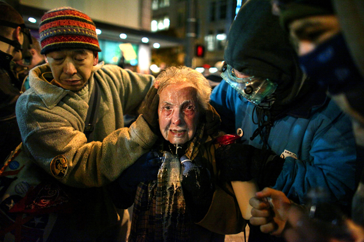 Seattle activist Dorli Rainey, 84, is helped by fellow Occupy Seattle protestors after being hit with pepper spray Nov. 15, 2011. (Joshua Trujillo)