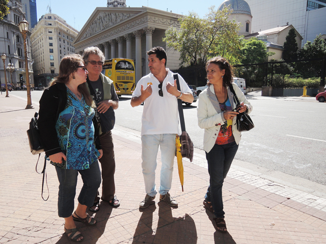 Javier Cortese, center, leads tours sponsored by the Buenos Aires, Argentina, municipal government on sites important or notable during the life of Pope Francis. The tours take in the city's cathedral with its neo-classical facade. (CNS/David Agren) 