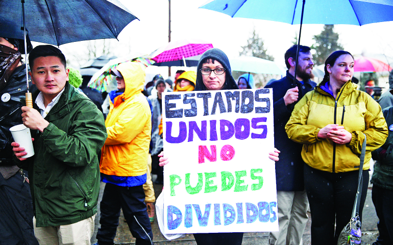 Nona Carrasco holds a sign Feb. 5 as part of human shield to protect worshipers at St. Peter Church in Portland, Ore., which suffered verbal attacks the previous week. Translated, the sign reads: "We who are united cannot be divided." (Francisco Lara/El Centinela)