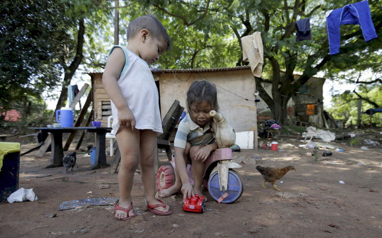 Children play outside their house March 31 in a slum in Asuncion, Paraguay. (CNS/Reuters/Jorge Adorno)