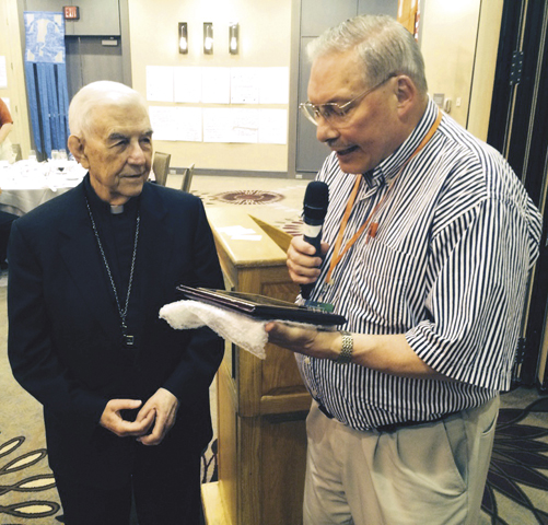 Association of U.S. Catholic Priests board chair David Cooper gives Archbishop Emeritus John R. Quinn the group's Pope John XXIII Award. (NCR Photo/Thomas C. Fox)