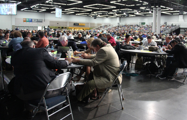 Delegates at the United Methodist Church General Conference in Portland, Ore., spent time in prayer on May 17, 2016 after Bishop Bruce Ough addressed rumors the denomination's Council of Bishops was considering a proposal to split the church. (RNS/Emily McFarlan Miller)