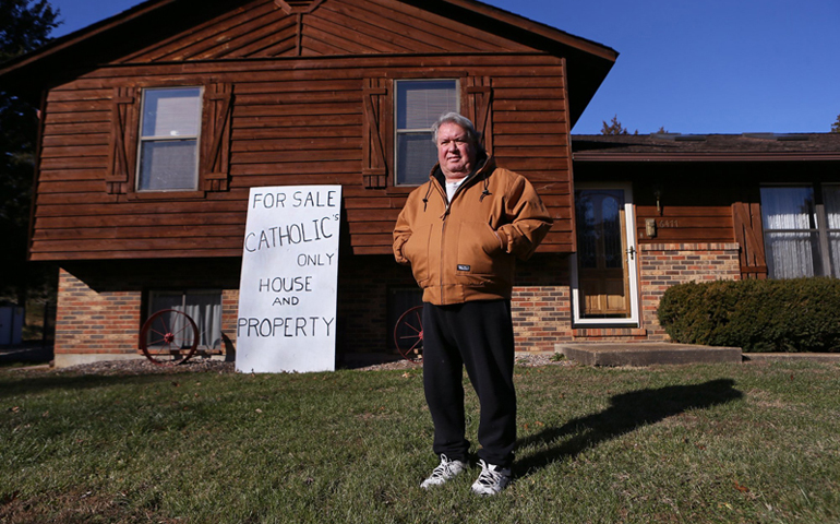 Mike Stenzhorn, 62, stands on his front lawn in Dittmer in December. Stenzhorn said he posted the sign in front of his house "to draw attention to the situation." "A devout Catholic that believes in the religion would be more apt to buy it," he added. (RNS/Courtesy of St. Louis Post-Dispatch/Cristina Fletes-Boutte)