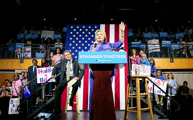 Presumptive Democratic presidential nominee Hillary Clinton speaks as U.S. Senator Sherrod Brown listens at the campus of the University of Cincinnati in Cincinnati, Ohio, July 18, 2016. (Courtesy of Reuters/William Philpott)