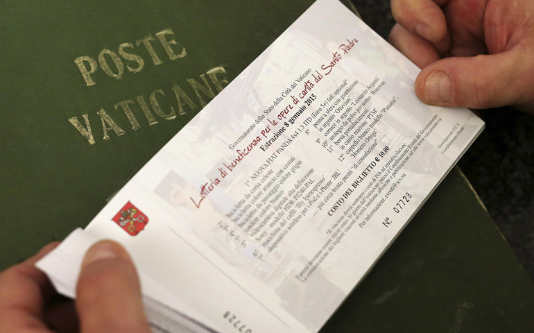 An employee of the Vatican Post Office shows a ticket of the pope's raffle Friday at the Vatican. (CNS/Reuters/Alessandro Bianchi)