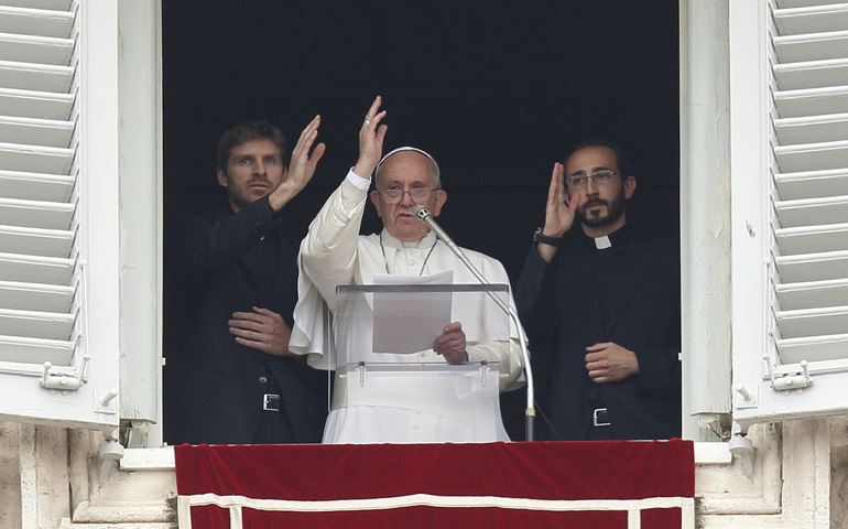 Pope Francis and two newly ordained priests give a blessing Sunday during the "Regina Coeli" led from the window of the pope's studio at the Vatican. The priests and 17 others were ordained by the pope during a liturgy in St. Peter's Basilica that morning. (CNS/Paul Haring)