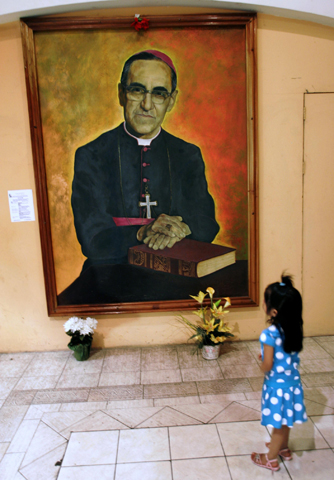 A girl looks at an image of Archbishop Oscar Romero in 2009 at the cathedral where he is buried in San Salvador. (CNS/Reuters/Luis Galdamez)