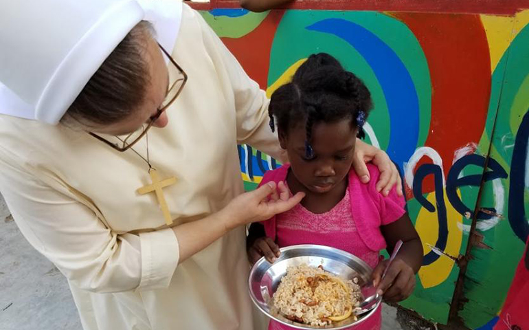 Felician Srs. Mary Inga Borko, left, and Marilyn Marie Minter, not shown, serve meals as part of a community-based after-school program for about 60 children in Jacmel. (GSR/Chris Herlinger)