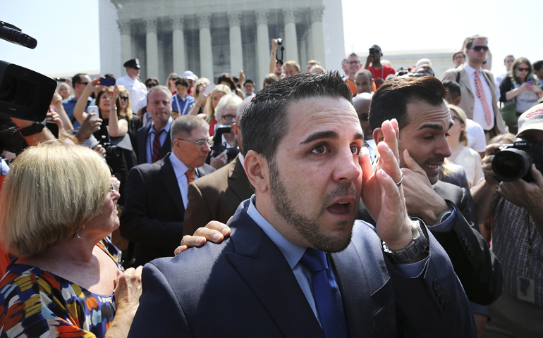 Jeff Zarrillo, center, and Paul Katami, right, plaintiffs in the case against California's same-sex ban known as Proposition 8, wipe away tears and greet supporters as they depart the Supreme Court on Wednesday in Washington. (CNS/Reuters/Jonathan Ernst)