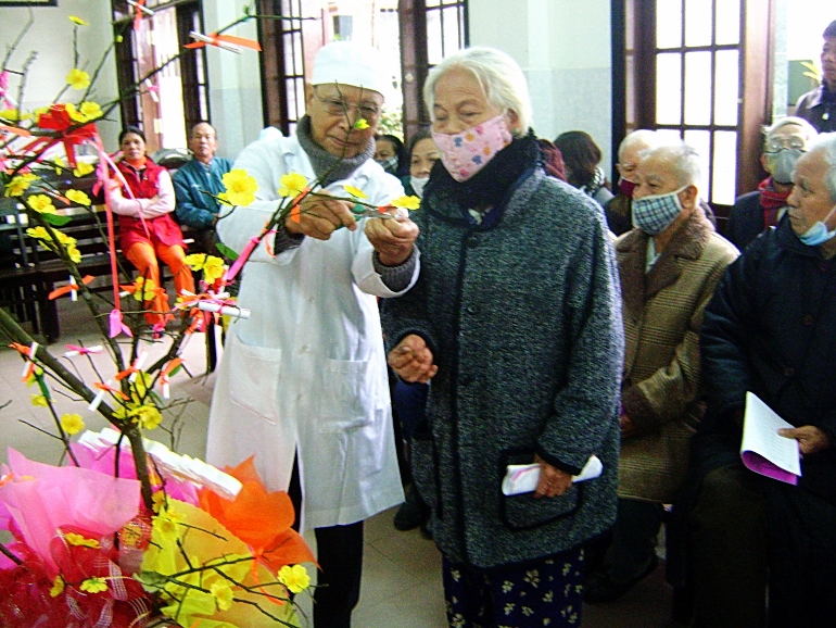 Patients pick "sacred buds" containing Scriptural passages offering educational and moral advice at a healthcare clinic run by sisters in Hue City. (Peter Nguyen)