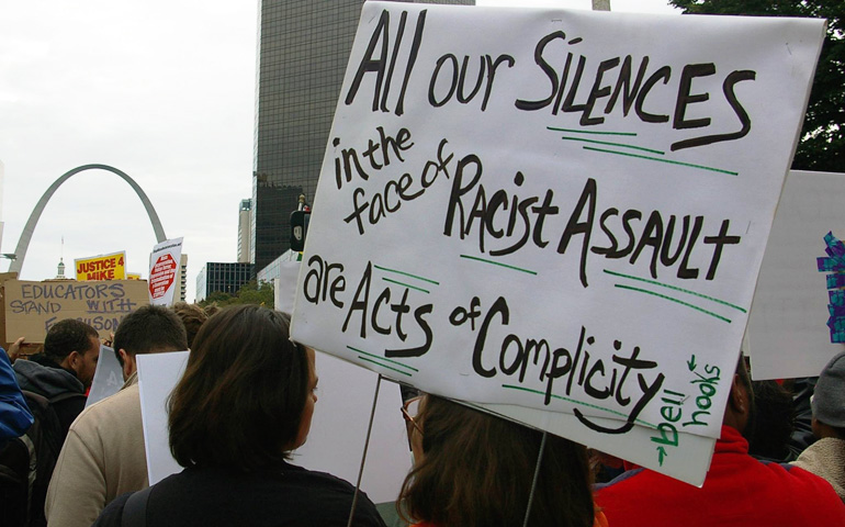 Jenny Truax, a member of St. Louis' Karen House Catholic Worker community, holes a sign surrounded by fellow Catholic Workers at an Oct. 11 march in St. Louis. (Courtesy of Karen House Catholic Worker)