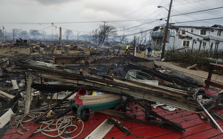 Homes devastated by fire and the effects of Hurricane Sandy are seen Tuesday in the Breezy Point section of Queens borough in New York. The storm knocked out power to huge swathes of the nation's most densely populated region, swamped New York's subway system and submerged streets in Manhattan's financial district. (CNS/Reuters/Shannon Stapleton)