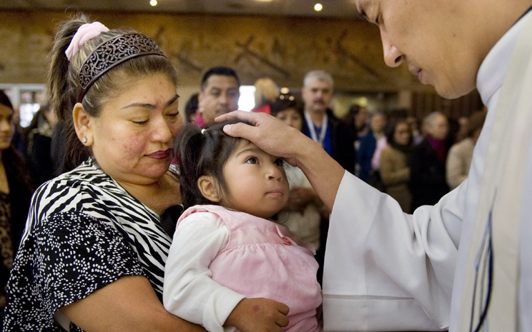 Two-year-old Milagros Perez takes part in the sacrament of the sick with her mother, Rosa Perez, and Fr. Eugene Lee at St. Columban Church in Garden Grove, Calif., Feb. 8. (Newscom/ZUMA Press/Mindy Schauer)