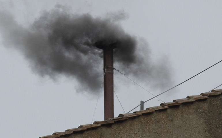 Black smoke emits from the chimney of the Sistine Chapel at the Vatican around noon Wednesday to signify a new pope was not elected. (CNS/Paul Haring)