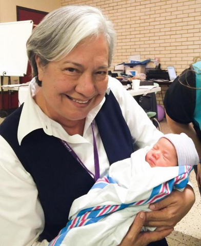 Missionaries of Jesus Sr. Norma Pimentel holds a newborn baby at the humanitarian respite center she started at Sacred Heart Church during an immigration surge in 2014. (Herminia Forshage/Courtesy of Catholic Charities of the Rio Grande)