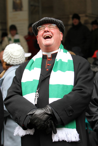 Cardinal Timothy Dolan of New York laughs while reviewing the 253rd annual St. Patrick's Day Parade on March 17 as it passes in front of St. Patrick's Cathedral in New York. (CNS/Gregory A. Shemitz)