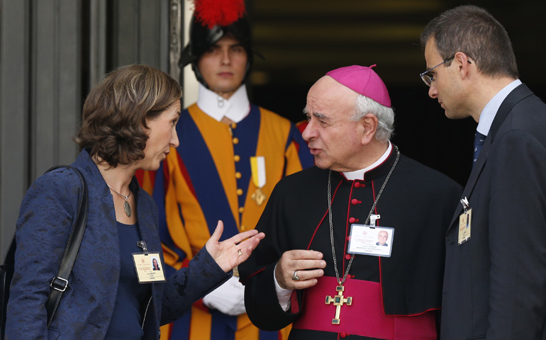 Archbishop Vincenzo Paglia, president of the Pontifical Council for the Family, talks with Xristilla and Olivier Roussy, auditors from France, as they leave the morning session of the extraordinary Synod of Bishops on the family Tuesday at the Vatican. (CNS/Paul Haring)