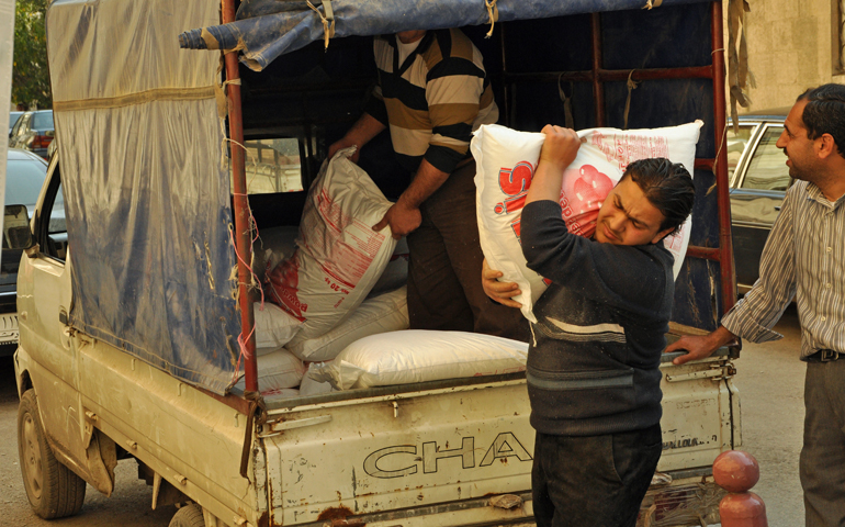 Men unload food at a Jesuit Refugee Service distribution warehouse in Aleppo, Syria. (Jesuit Refugee Service Aleppo)