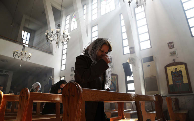 An Assyrian woman prays at a church in Damascus during a special Mass on March 1 for Assyrian Christians abducted by Islamic State fighters. (CNS/Reuters/Omar Sanadiki)