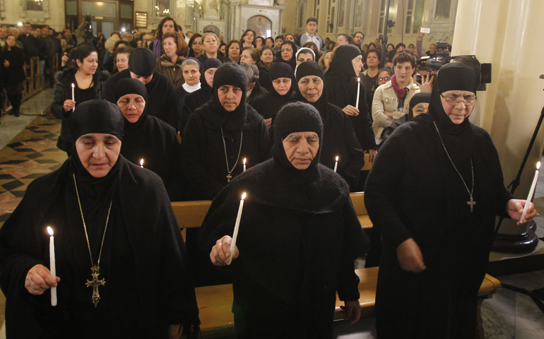 Mother Plagia Sayyaf of Mar Thecla monastery in Maaloula, Syria, left, who along with at least 11 other nuns was freed after three months, attends a prayer service Monday at the Greek Orthodox Church of the Holy Cross in Damascus. (CNS/Reuters/Khaled al-Hariri)