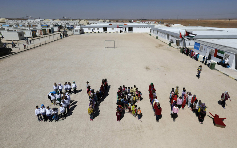 Syrian refugee children at the Mrajeeb Al Fhood refugee camp in Jordan form the word "Syria" during a March 15 event to commemorate four years of the Syrian conflict. (CNS/Reuters/Muhammad Hamed)