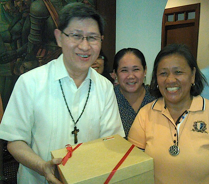 Members of Urban Poor Alliance and leaders of organizations and institution advocating housing and other rights of the poor hand Cardinal Luis Tagle of Manila (left) a box of home-made apple pie at their meeting in the archbishop’s residence Jan. 7. (Rosalio Obnamia)