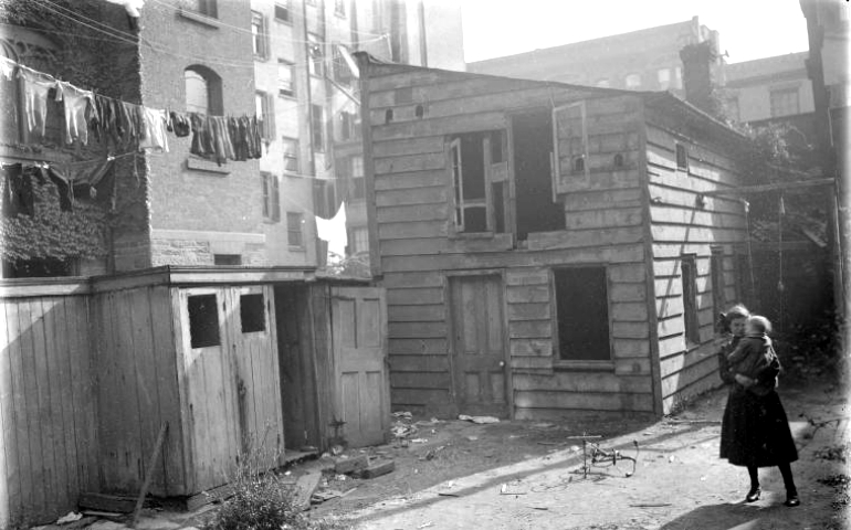 View of back of tenement housing in early 20th-century New York, typical of where immigrants lived (From the New York Public Library archives, photographic negative of the NYC Tenement Housing Department, 1902-1914)