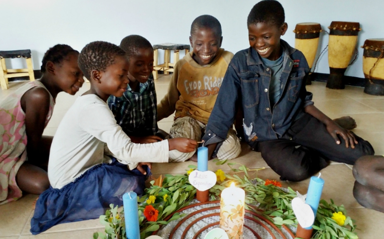 Children light an Advent wreath at the Garden of Oneness in rural Zambia. The wreath has a cosmic spiral at the center holding the unfolding love story of God -- within this story Jesus was born among us. (Provided photo)