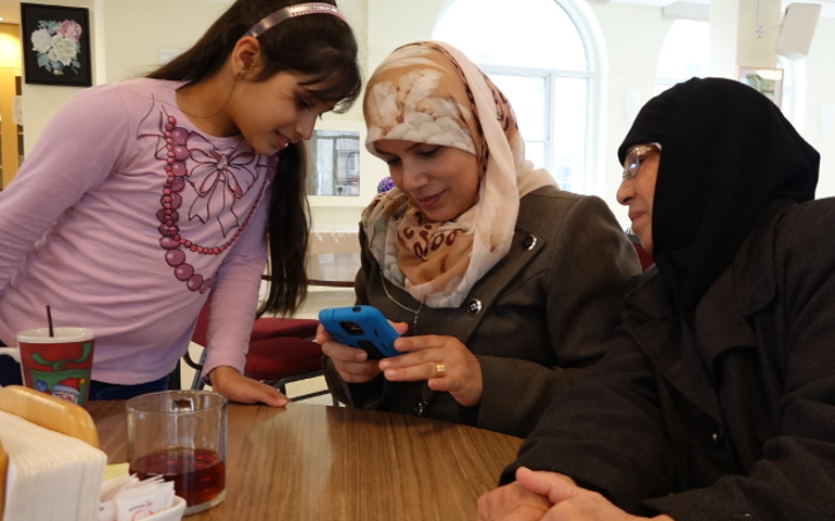 Three generations of this Syrian family (Agha) made it safely to Canada together. They enjoy snapping photos and sharing them with each other. (GSR photo / Dana Wachter)